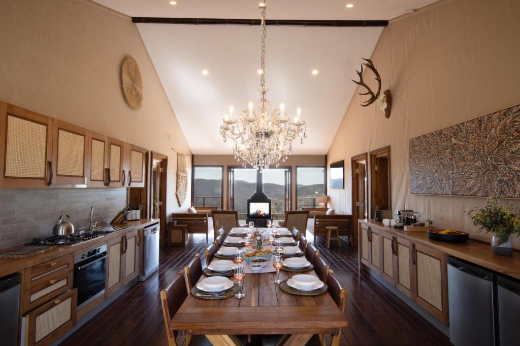 a long table in a kitchen with a chandelier at Turon Gates - Mountain Retreat in Capertee
