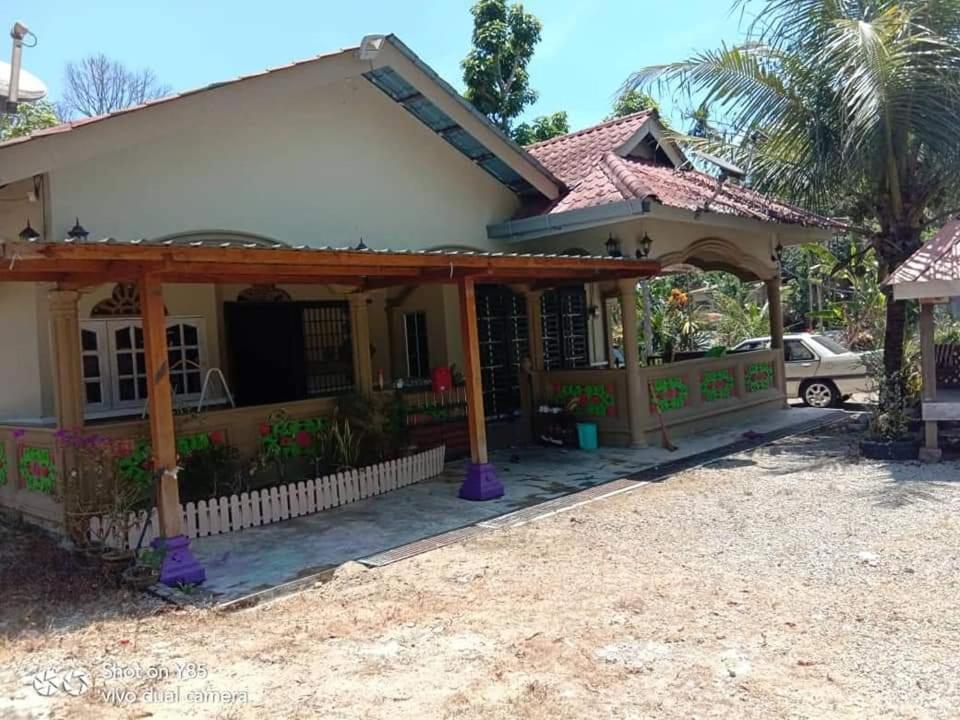 een huis met een pergola ervoor bij D’sireh homestay in Sik