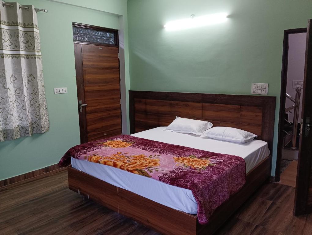 ein Schlafzimmer mit einem Bett mit einem Kopfteil aus Holz in der Unterkunft Crescent Moon Homestay in Rishikesh