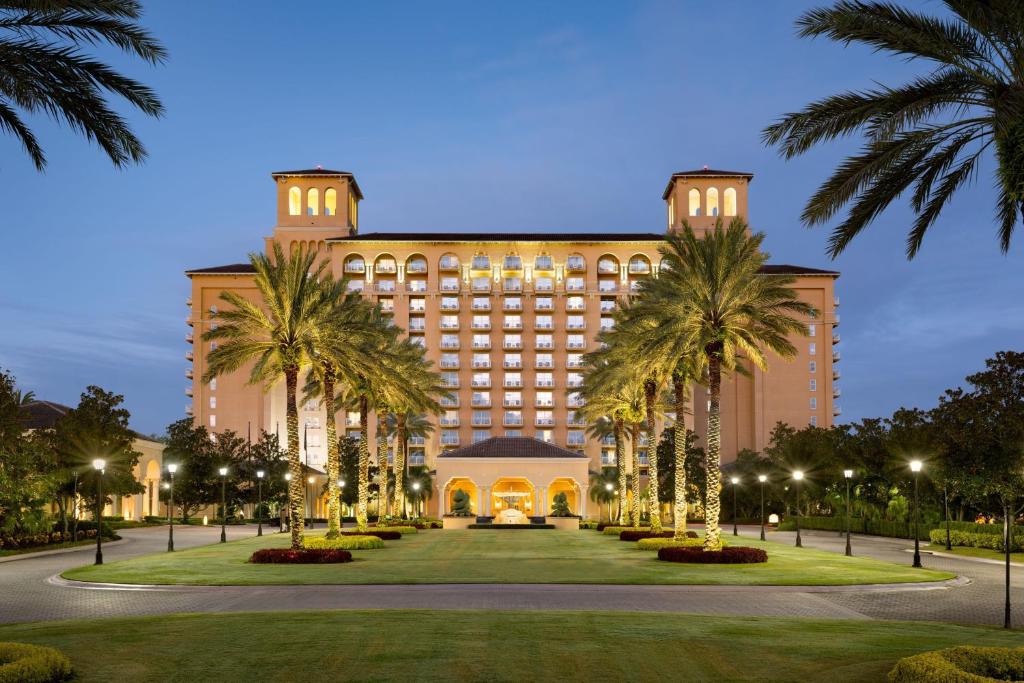 um grande edifício com palmeiras em frente em The Ritz-Carlton Orlando, Grande Lakes em Orlando