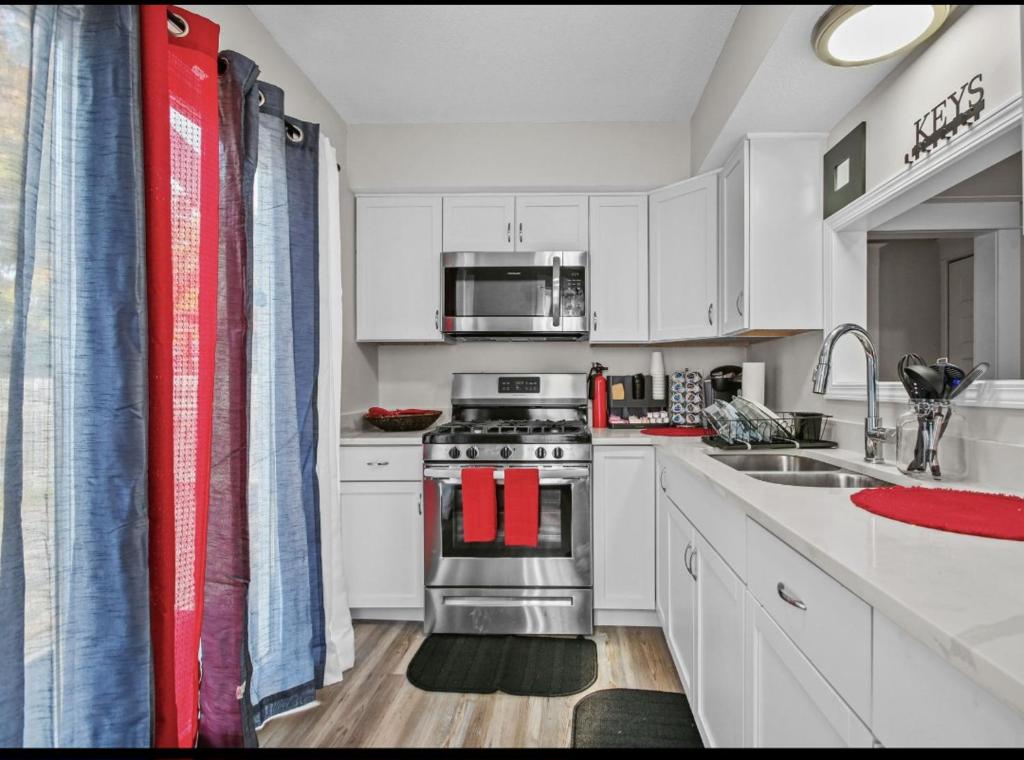 a kitchen with white cabinets and a stainless steel stove at St Paul Fry Street Den Suite#1 in Saint Paul