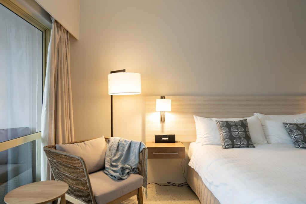 a hotel room with a bed and a chair and a table at The Marina Hotel - Mindarie in Mindarie