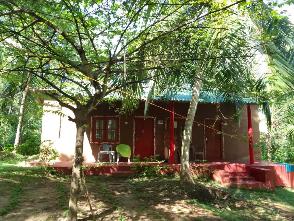 une maison dans les bois avec deux arbres dans l'établissement Peacock Family Stay, à Tangalle