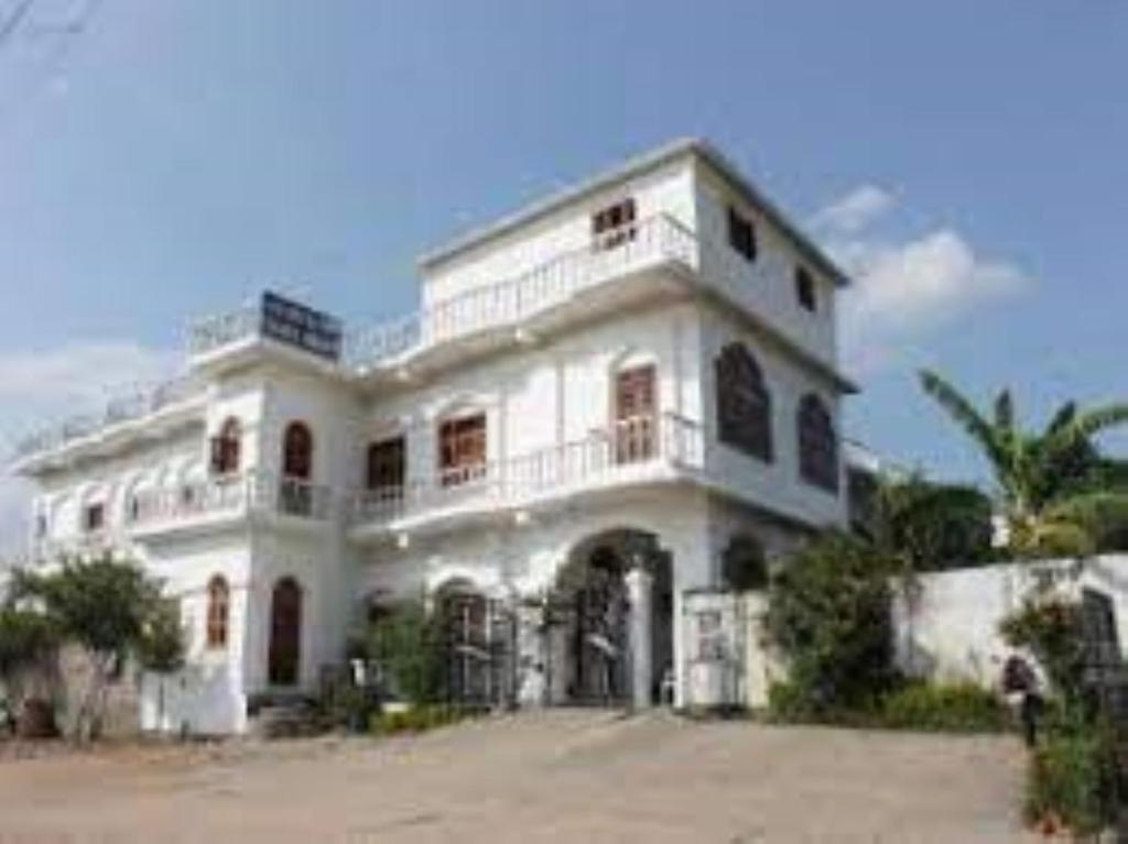 duży biały budynek z balkonem w obiekcie Hotel Isabel Palace, Khajuraho w mieście Khajuraho