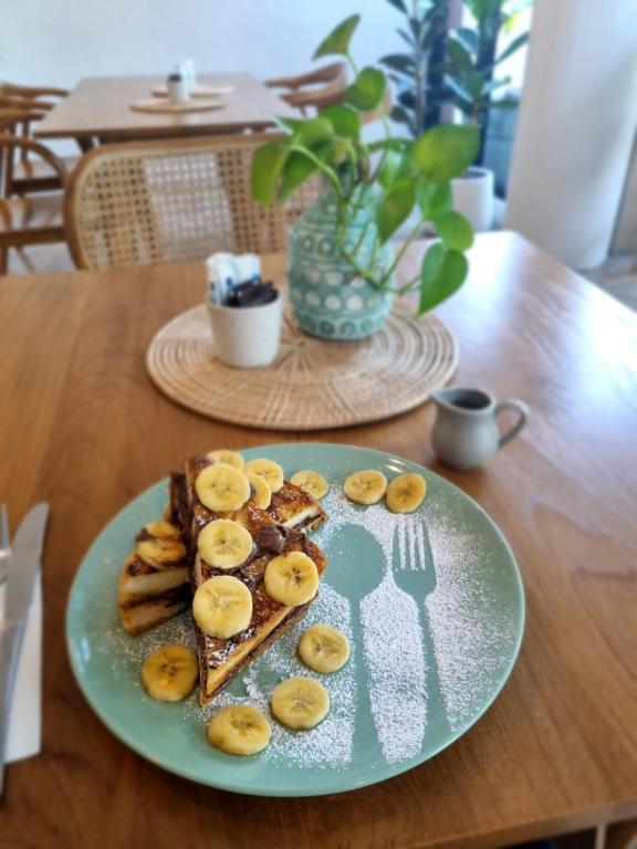 French toast with banana is served at a wooden breakfast table.