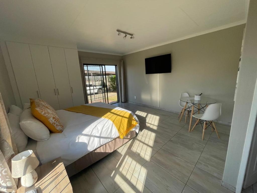a bedroom with a bed and a television and a table at Oaktree in Ermelo