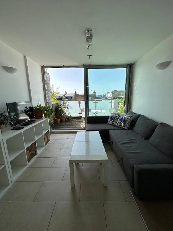 uma sala de estar com um sofá e uma mesa em Bright And Airy Islington Apartment em Londres