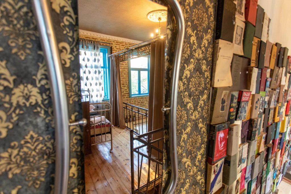 espejo en una habitación con libros en la pared en Book Hotel, en Kutaisi