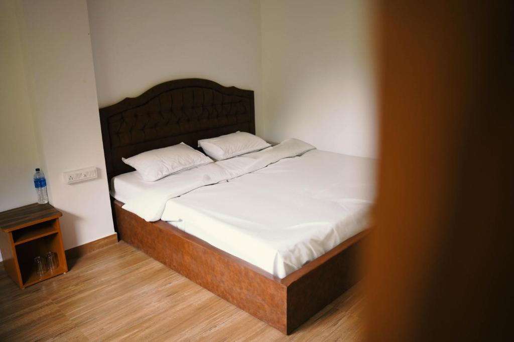 a bed with white sheets and pillows in a room at Nature Cascade Resort in Chillithodu