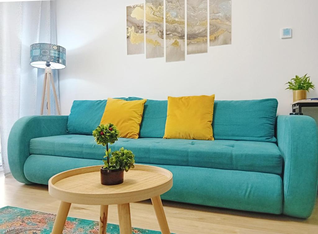 ブカレストにあるSUNSHINE - New & Quiet 1BR Apt, Business area, close to Airport, Highway A3, Subwayのリビングルーム(青いソファ、テーブル付)