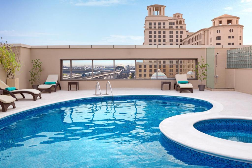 a swimming pool on the roof of a building at Flora Al Barsha Hotel At The Mall in Dubai