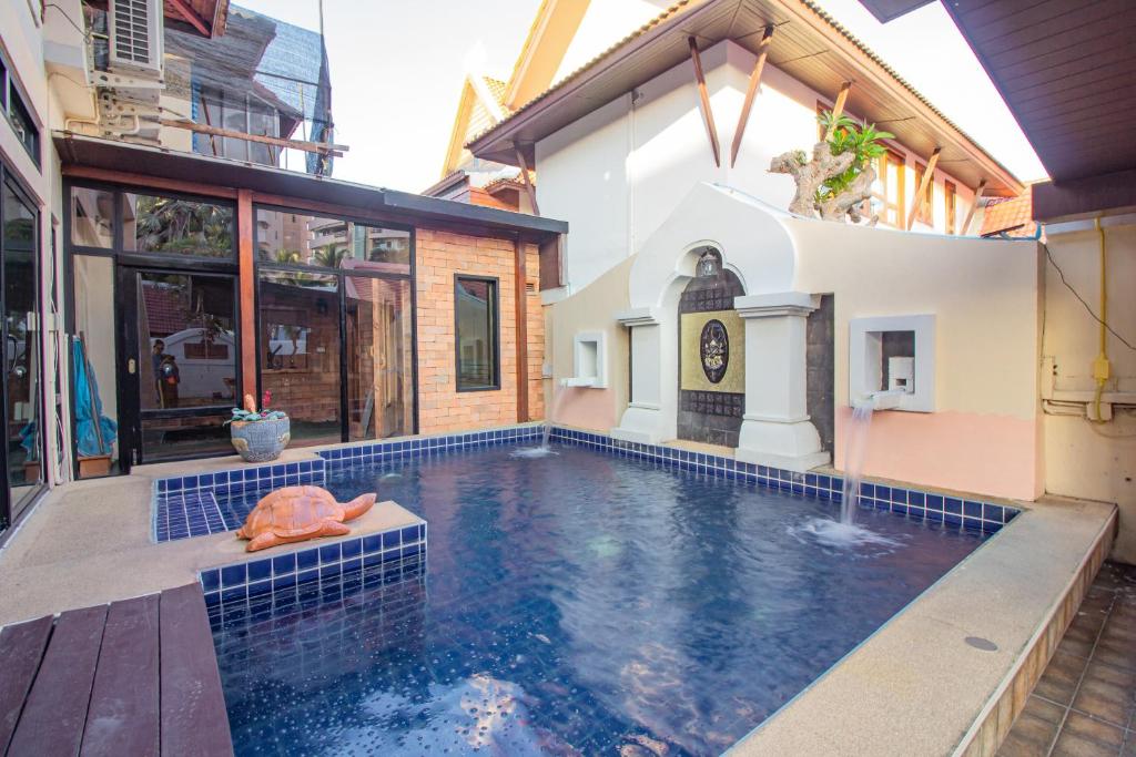 a swimming pool in front of a house at Thabali Oasis:3BHK private pool villa + Sauna in Pattaya South