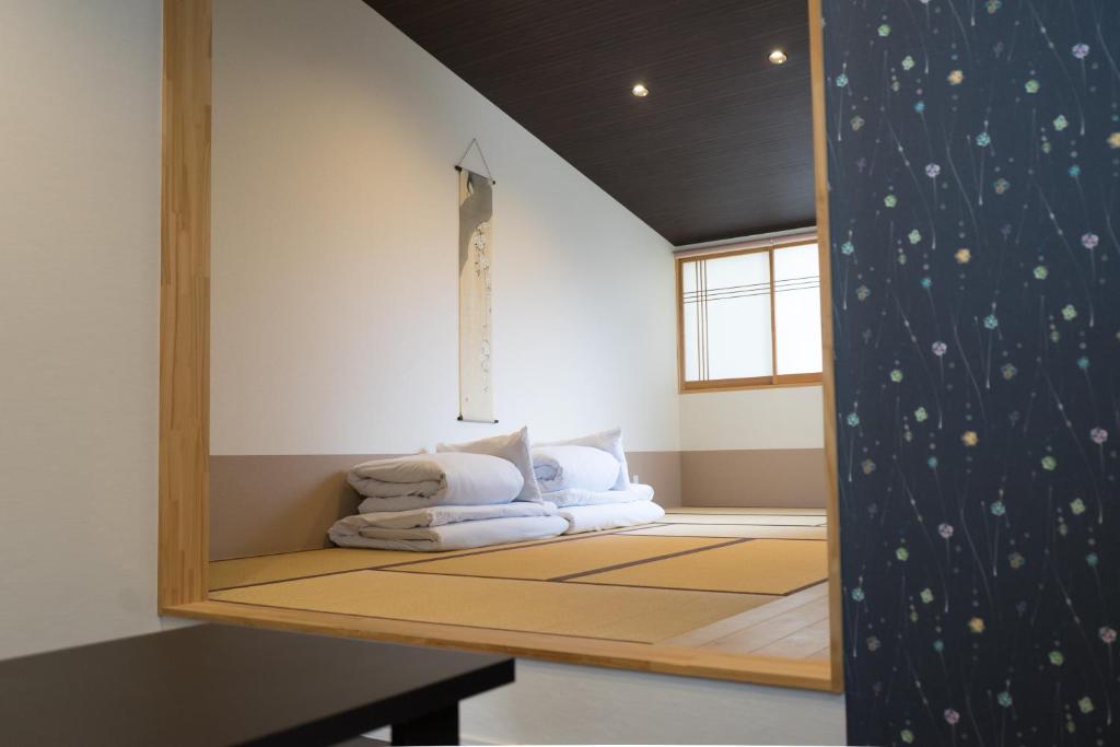 a room with a bed with a mirror on the wall at Guesthouse ZenNichi in Kyoto