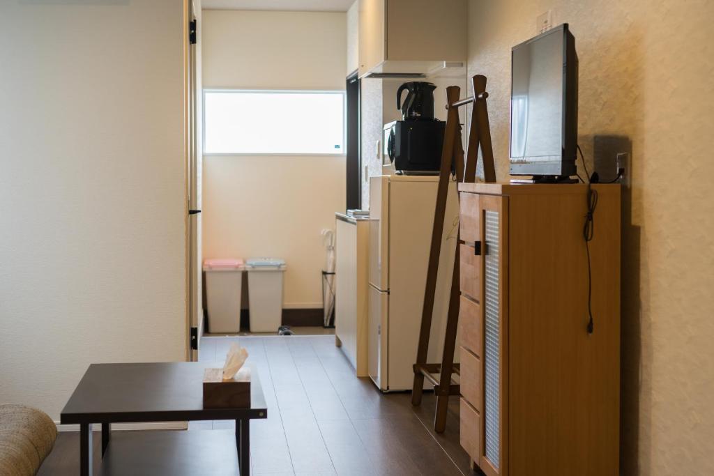 a living room with a refrigerator and a table at Guesthouse ZenNichi in Kyoto