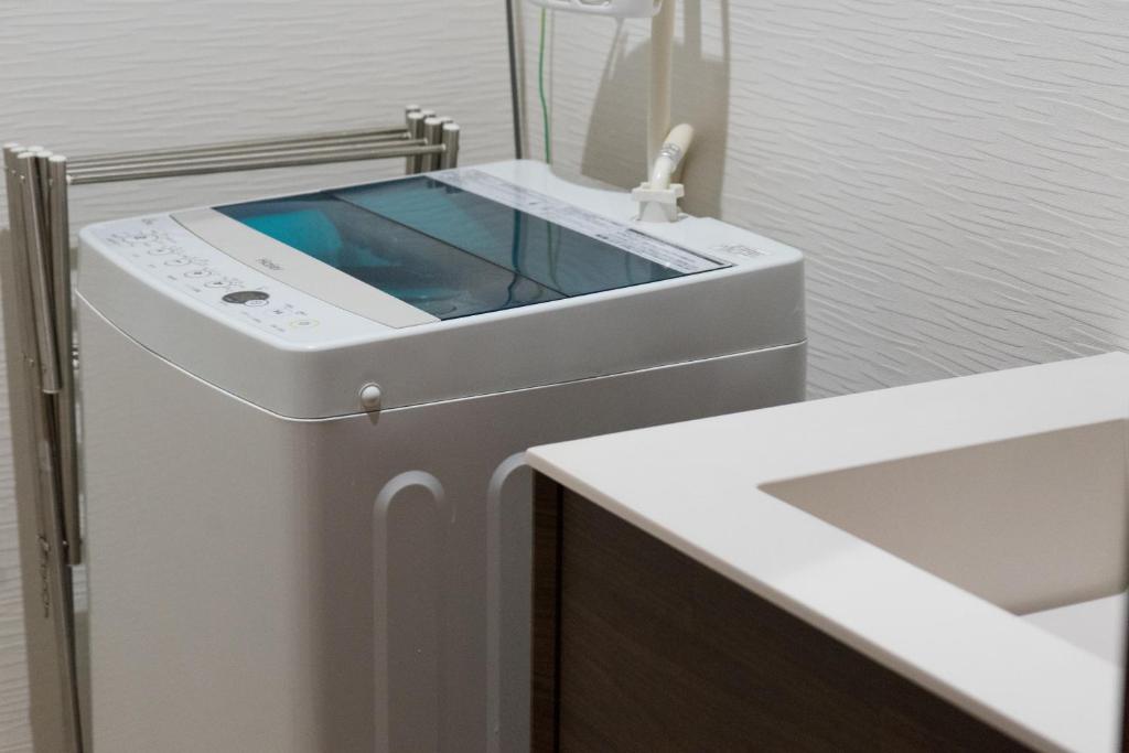 an iphone sitting on top of a washing machine at Guesthouse ZenNichi in Kyoto