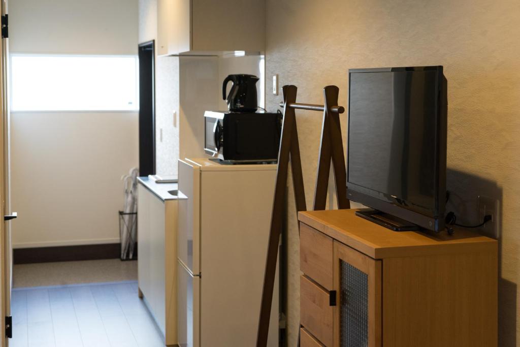 a television sitting on top of a dresser in a room at Guesthouse ZenNichi in Kyoto