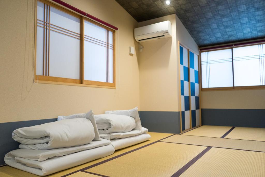 a room with three pillows sitting on the floor at Guesthouse ZenNichi in Kyoto
