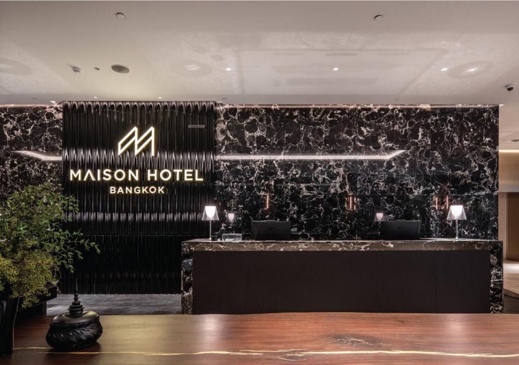 A polished reception desk set against dramatic black marble walls.