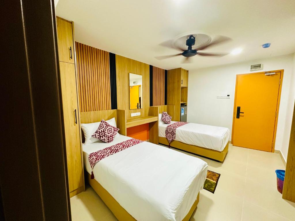 A bright twin room with two beds, a ceiling fan and built-in storage.