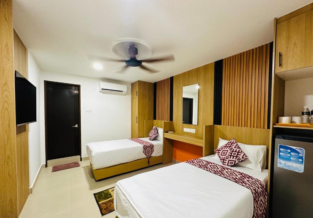 A twin room with a television, work desk, minibar and ceiling fan.