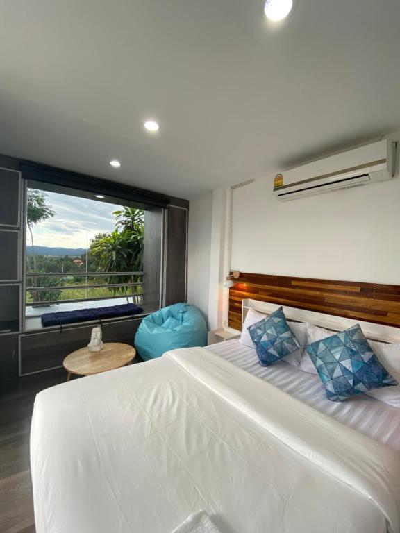 a bedroom with a large bed and a large window at 17Stories in Pai