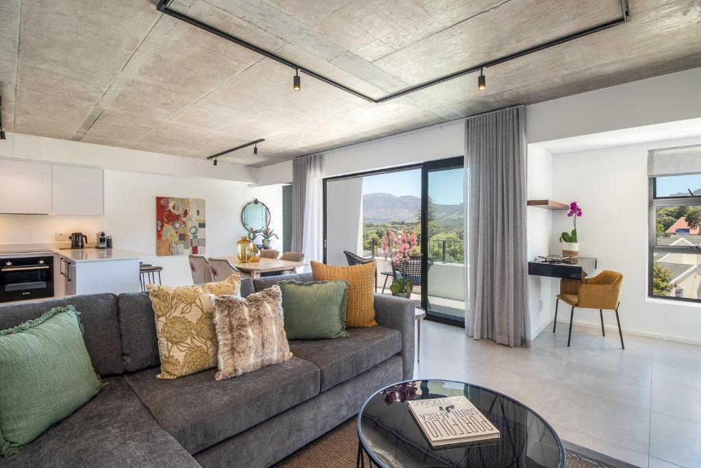 een woonkamer met een bank en een tafel bij Luxury Escape at Alphen Glen Constantia in Kaapstad