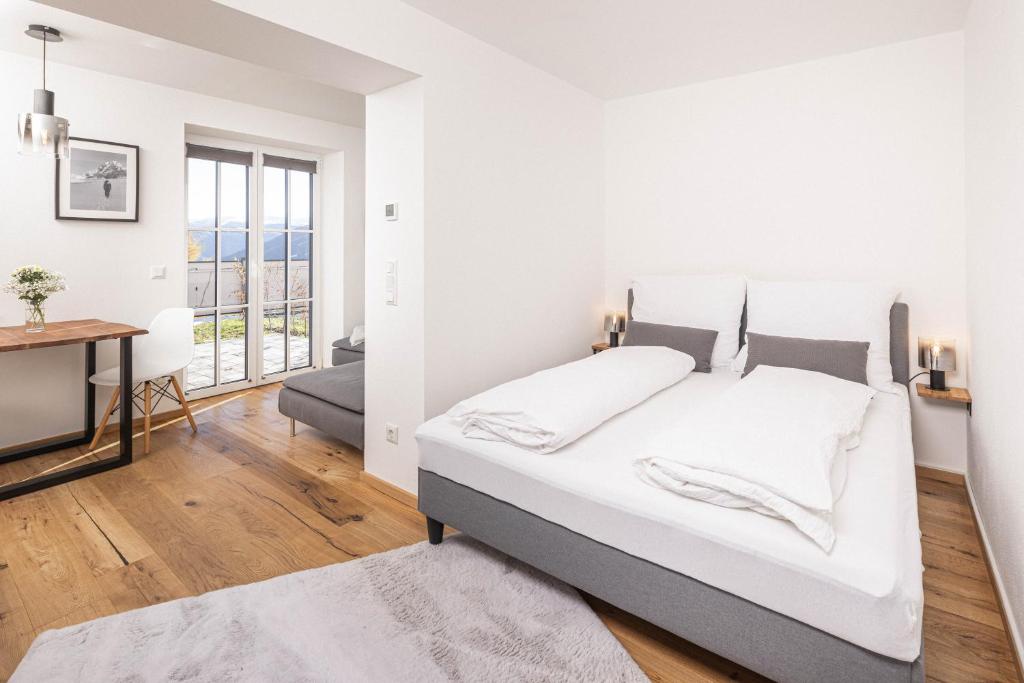 um quarto branco com uma cama e uma secretária em Apartment - Lärchenhof em Mauterndorf