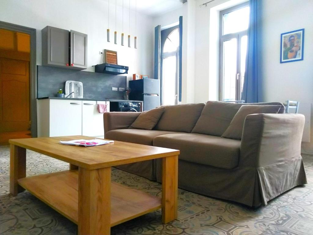 uma sala de estar com um sofá e uma mesa em Sublime et spacieux logement - Beau quartier Le Cours Foucault - 4 couchages - Places de stationnements gratuites - Balcon et vue sur Parc arboré - 5 min à pied de l'hypercentre Montauban em Montauban