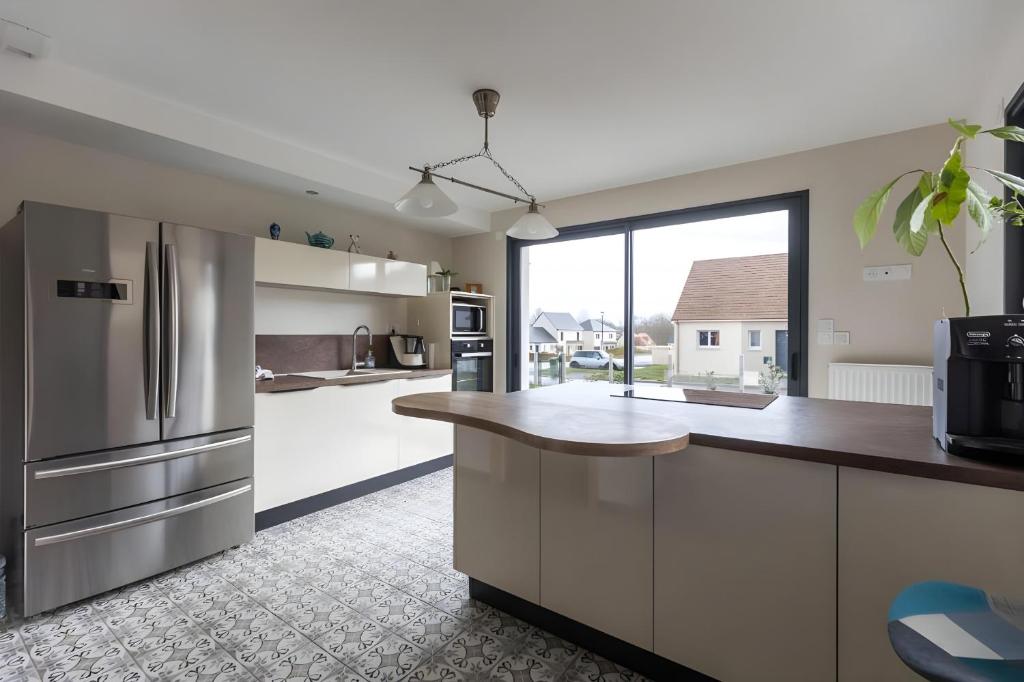 a kitchen with white cabinets and a large window at Cassiopée - Jacuzzi - Unique - 8p - Rêve au Mans in La Bazoge