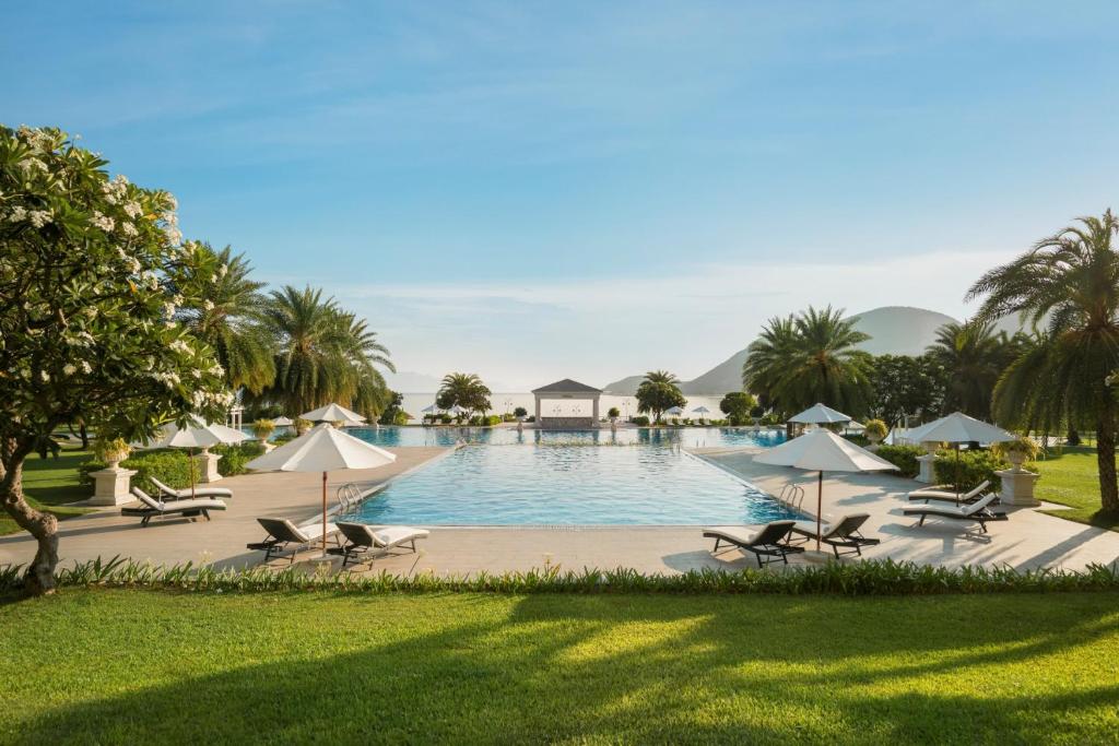 uma piscina com cadeiras e guarda-sóis num resort em Nha Trang Marriott Resort & Spa, Hon Tre Island em Nha Trang