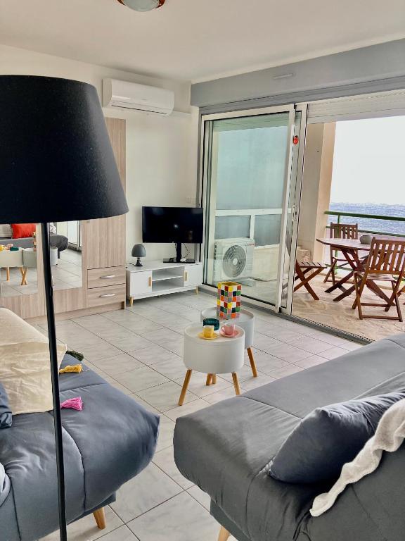 un salon avec un canapé et une vue sur l'océan dans l'établissement studio cosy avec vue panoramique, à Luri