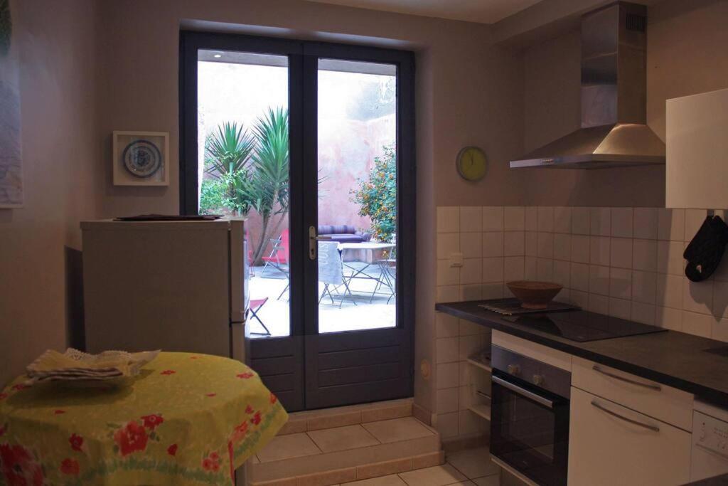 a kitchen with a door leading to a patio at Arlette la petite maison Arlésienne in Arles