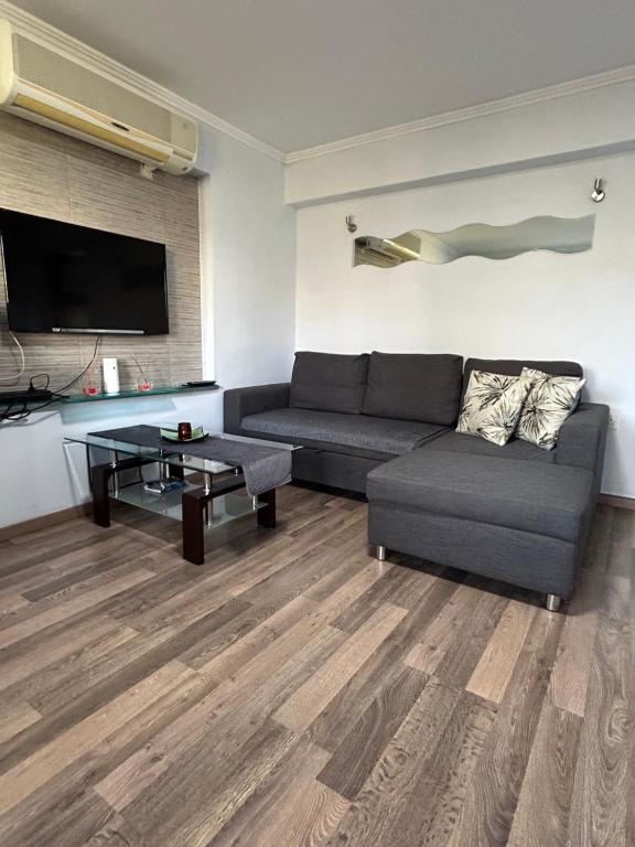 uma sala de estar com um sofá e uma mesa em Apartment with garden em Pafos