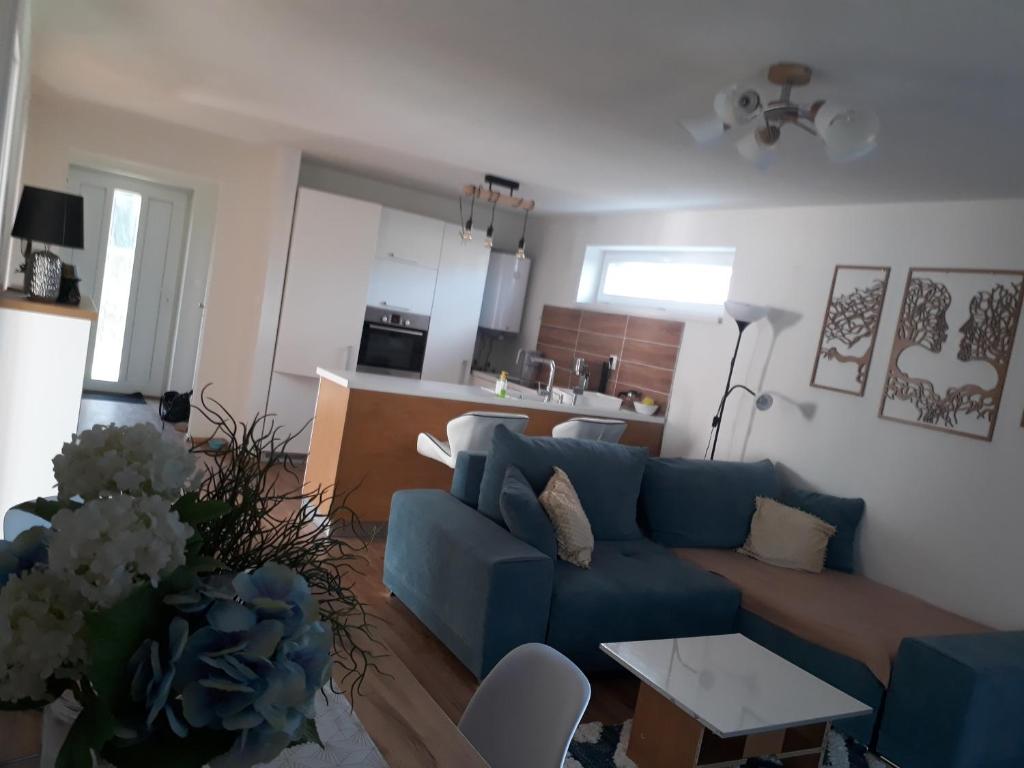 sala de estar con sofá azul y cocina en 3 izbovy RD - bungalow en Bernolákovo