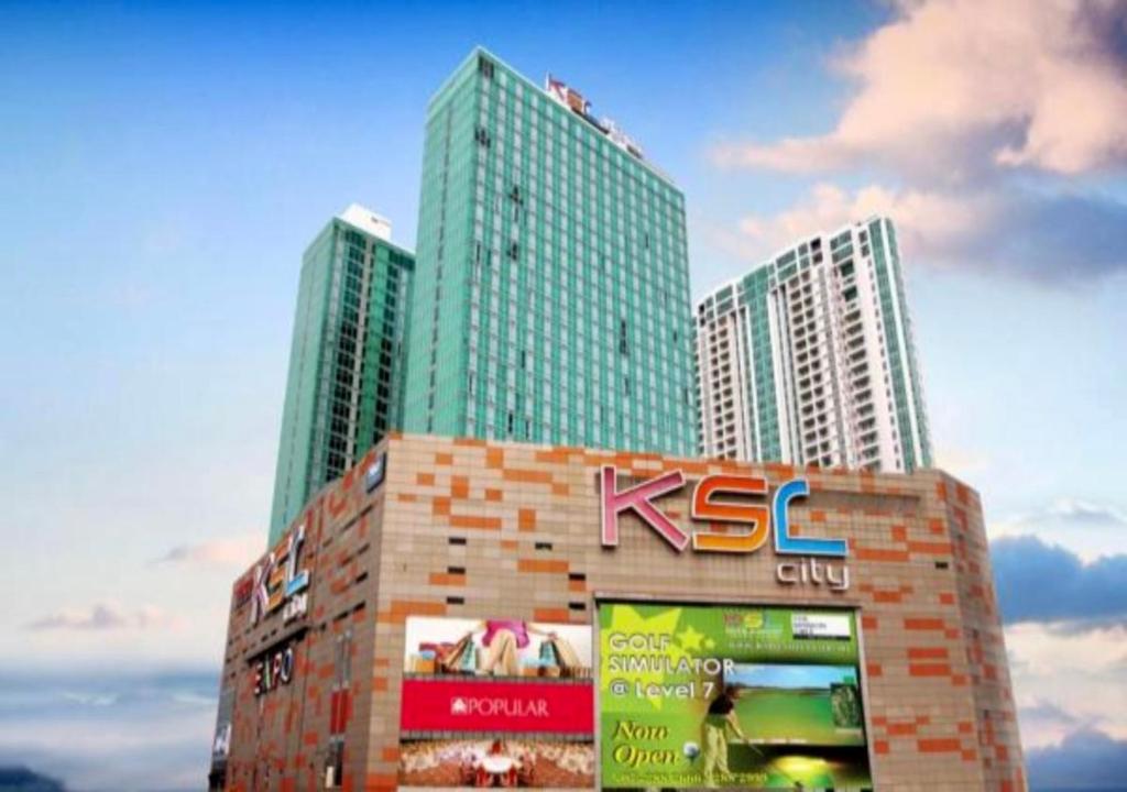 two tall skyscrapers in a city with a sign at JB City Shopping Mall Apartment in Johor Bahru