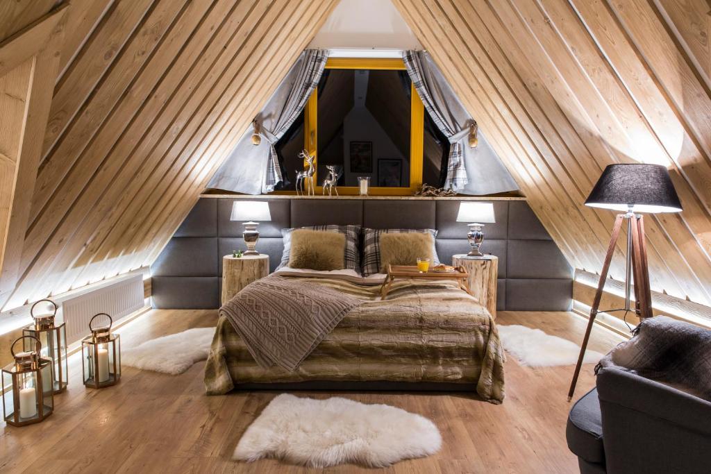 コシチェリスコにあるudanypobyt Apartament Marmotのベッドルーム1室(ベッド1台付)、窓のある屋根裏部屋