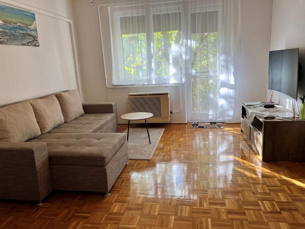 uma sala de estar com um sofá e uma mesa em Karman Apartman - 2 bedroom entire flat in the center em Jászberény