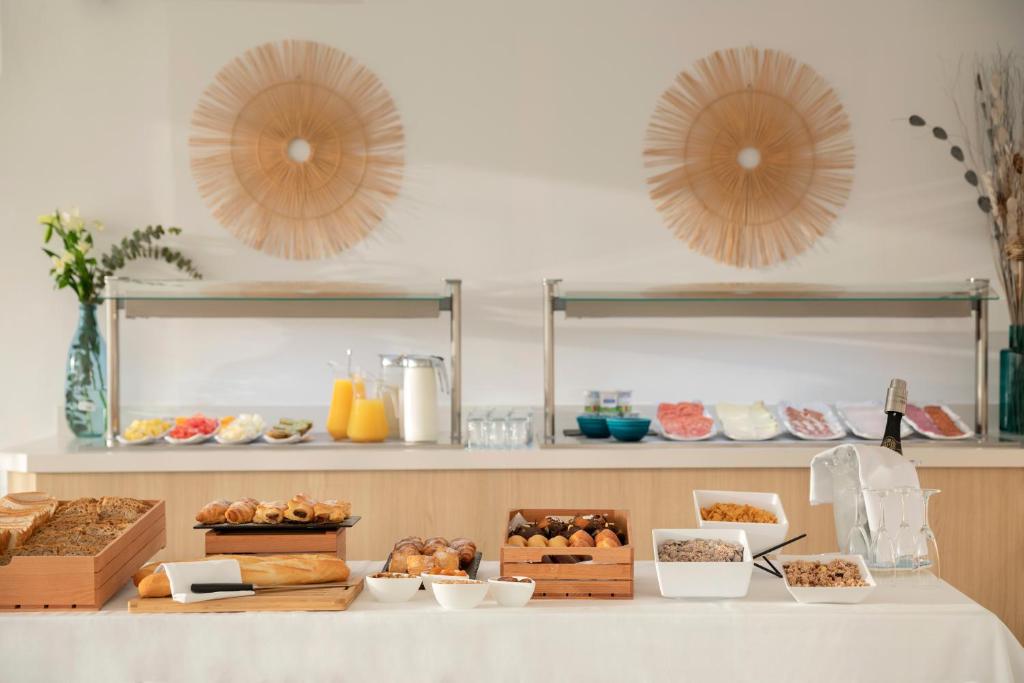 a table with various pastries and other food items at Porto Drach Aparthotel & Suites in Porto Cristo