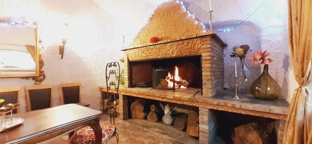 a fireplace in a living room with a table and a table sidx sidx at DIMORA IL CAMALEONTE country apartments with pool in Civitavecchia