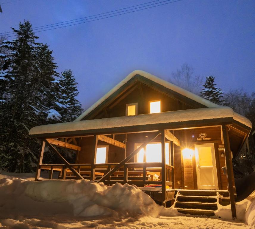 una cabaña de madera en la nieve por la noche en Field Tree - Vacation STAY 87164v en Kombu