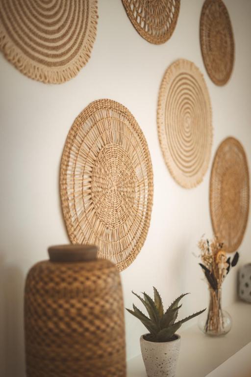 a wall with straw plates on a wall with a plant at KozyKaz, notre villa cocooning avec piscine in Saint-Pierre