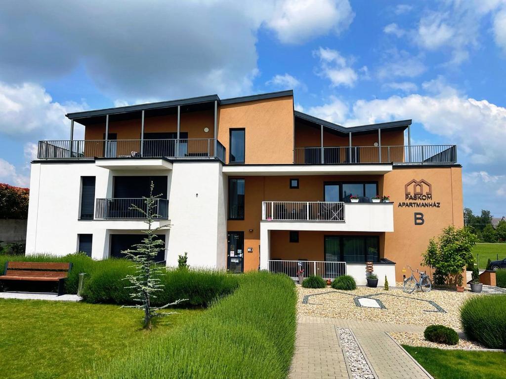 a large building with a garden in front of it at Paskom Apartmanház in Nyergesújfalu