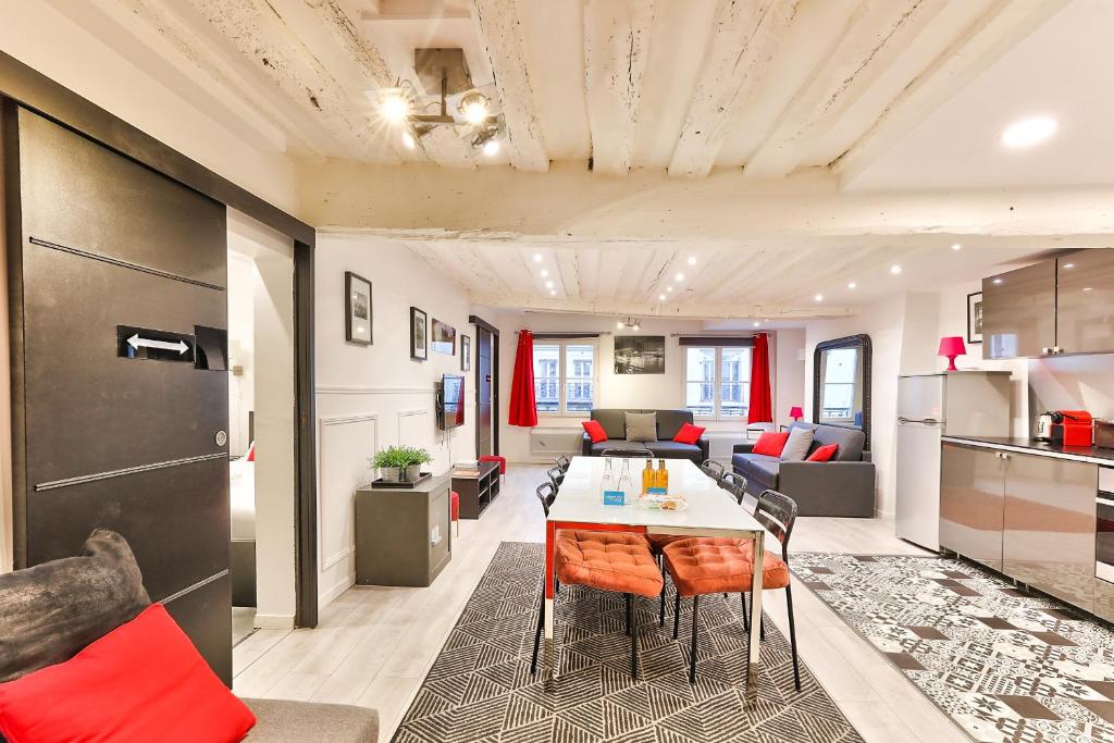 ein Wohnzimmer mit einem Sofa und einem Tisch in der Unterkunft 100 - Luxury 2 Bedroom - Beaubourg Marais in Paris