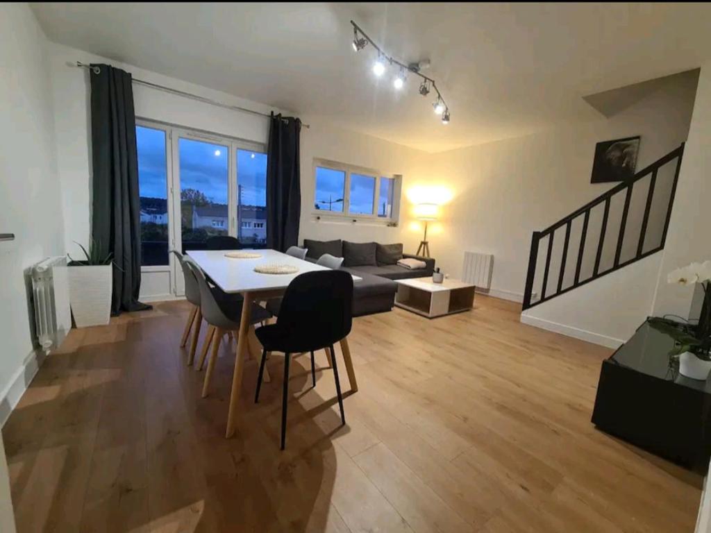 un salon avec une table, des chaises et un canapé dans l'établissement Duplex familial proche gare et hyper centre ville, à Villepreux
