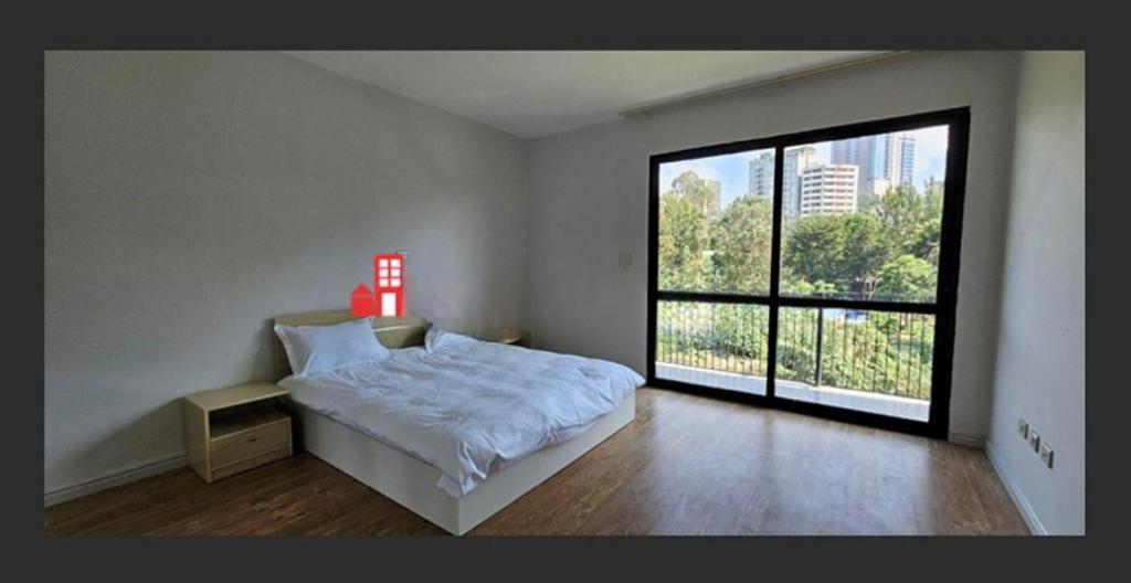 - une chambre avec un lit blanc et une grande fenêtre dans l'établissement Aman real estate, à Addis-Abeba