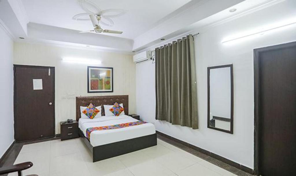 a bedroom with a bed and a mirror in it at FabHotel F9 H Block Sector 51 in Noida