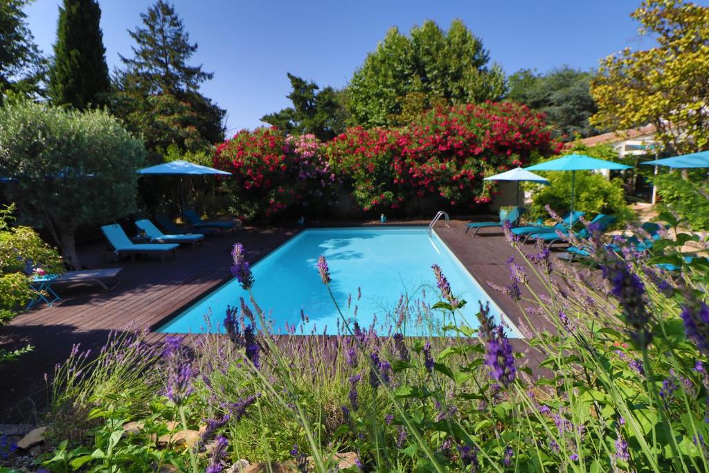 einen Pool in einem Garten mit Sonnenschirmen in der Unterkunft Le Mas de Bertagne in Gémenos