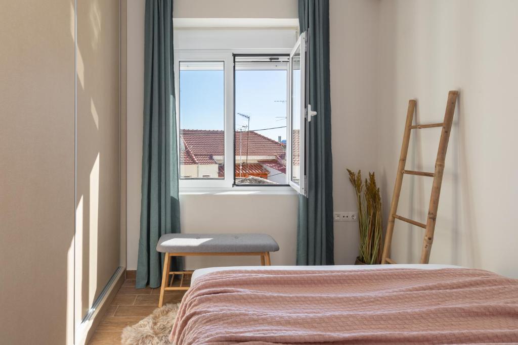 1 dormitorio con 1 cama, 1 silla y 1 ventana en Mikrolimano Gem: Serene 1BR Apartment, en Pireo