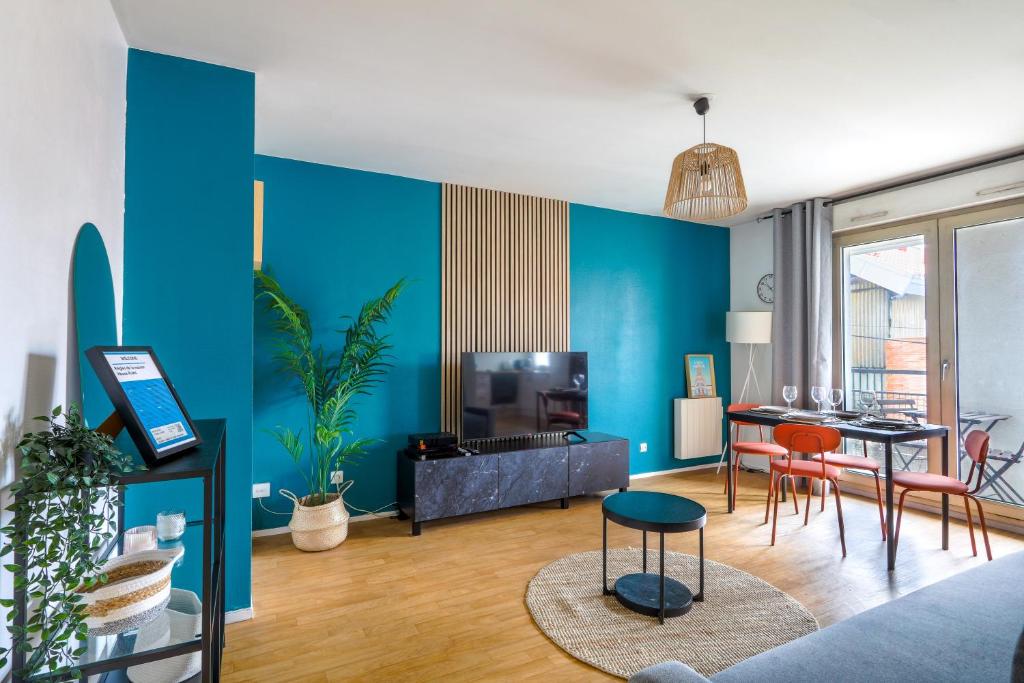 sala de estar con paredes azules, mesa y sillas en Cocon Urbain à 2 pas de la Gare en Nantes