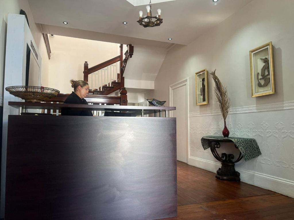 a woman standing behind a counter in a room at HEBA GUEST LODGE in Uitenhage